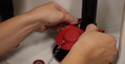 this image shows you how to attach a new toilet flapper to the flush valve