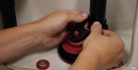 this image shows how to remove an old flapper from a flush valvee